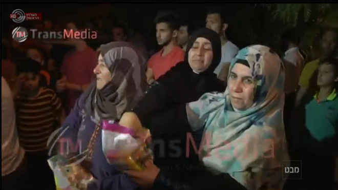 Abu Srour's relatives hand out candies to celebrate his shaheed status.