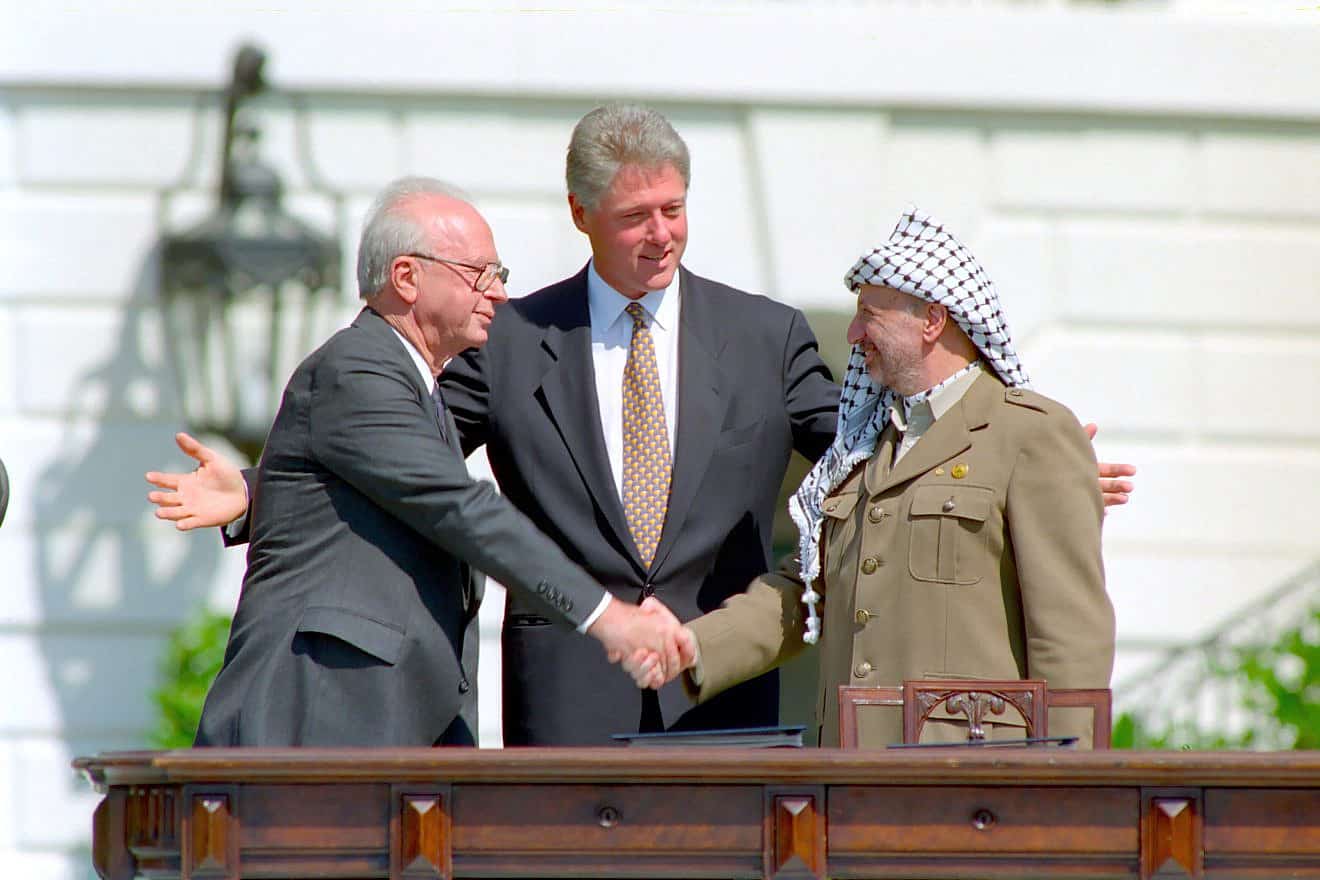 Rabin and Arafat shake hands in front of President Clinton.
